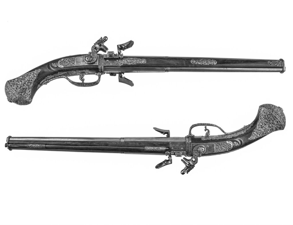 Pietro Alzano, Brescia seconda metà del XVII secolo. Coppia di pistole a due canne Ferro inciso e cesellato, radica di noce Misure: lunghezza cm 60